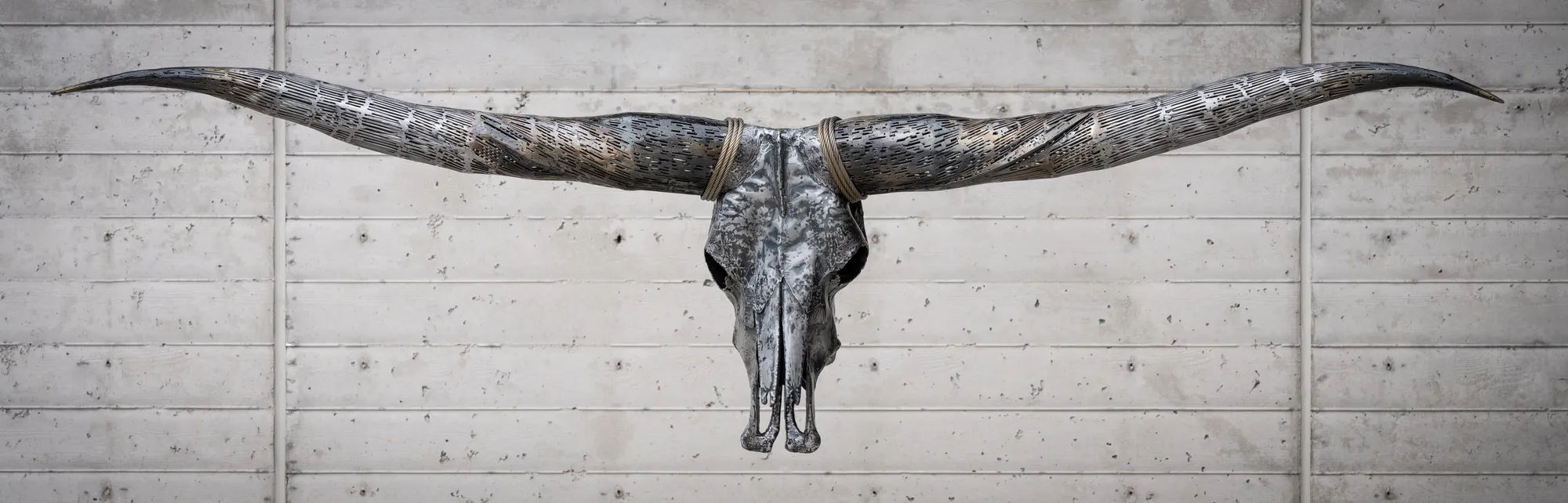 Twist of Fate, Hand hammered sheet metal, welded and textured; brass coated horns and wire rope