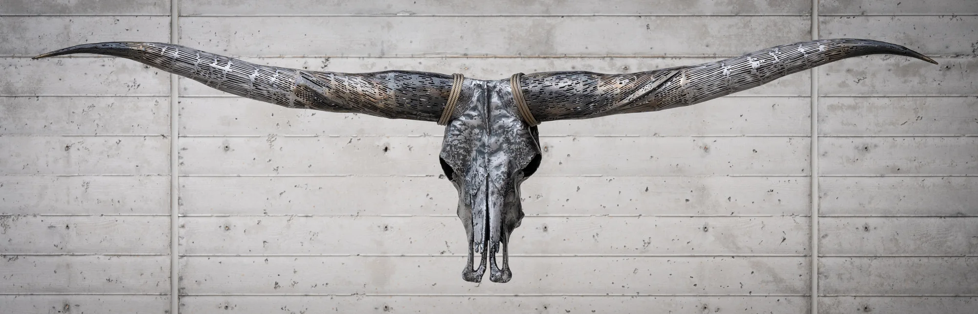 Twist of Fate, Hand hammered sheet metal, welded and textured; brass coated horns and wire rope