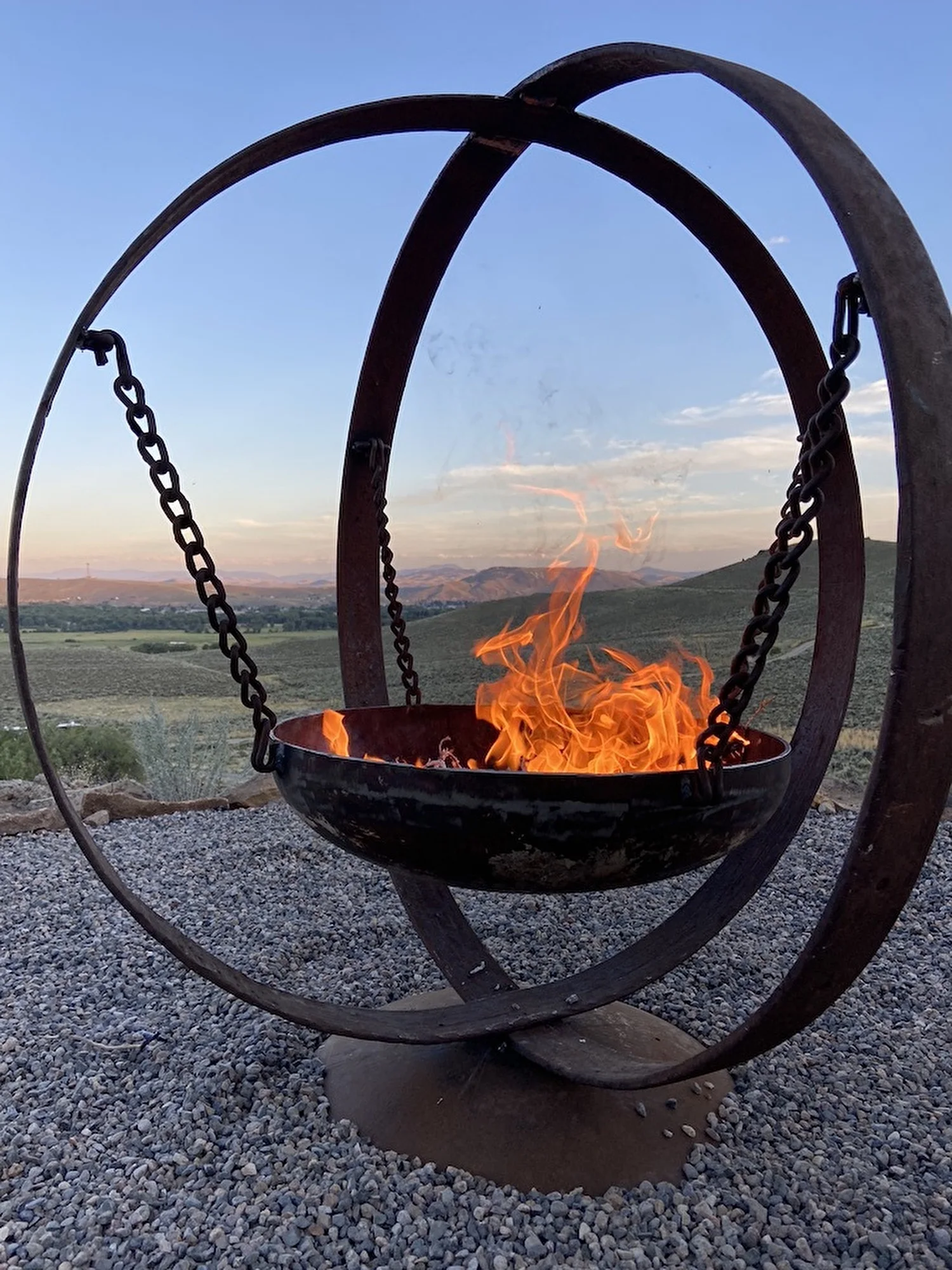 Wagon Wheel Fire Pit, 100+ year old wagon wheels, acetylene/propane tank end, twisted tire chains, steel drum flowers